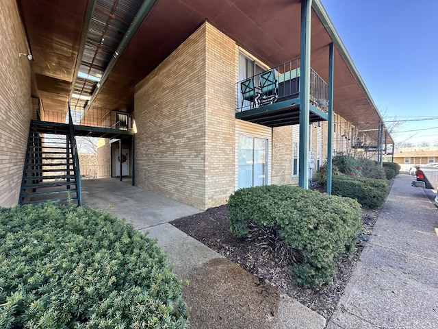 view of side of property with brick siding and stairs