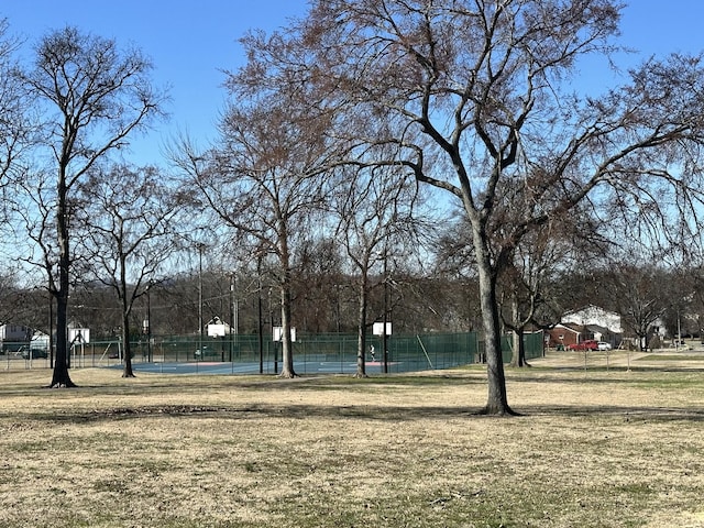 view of community featuring a yard, community basketball court, and fence