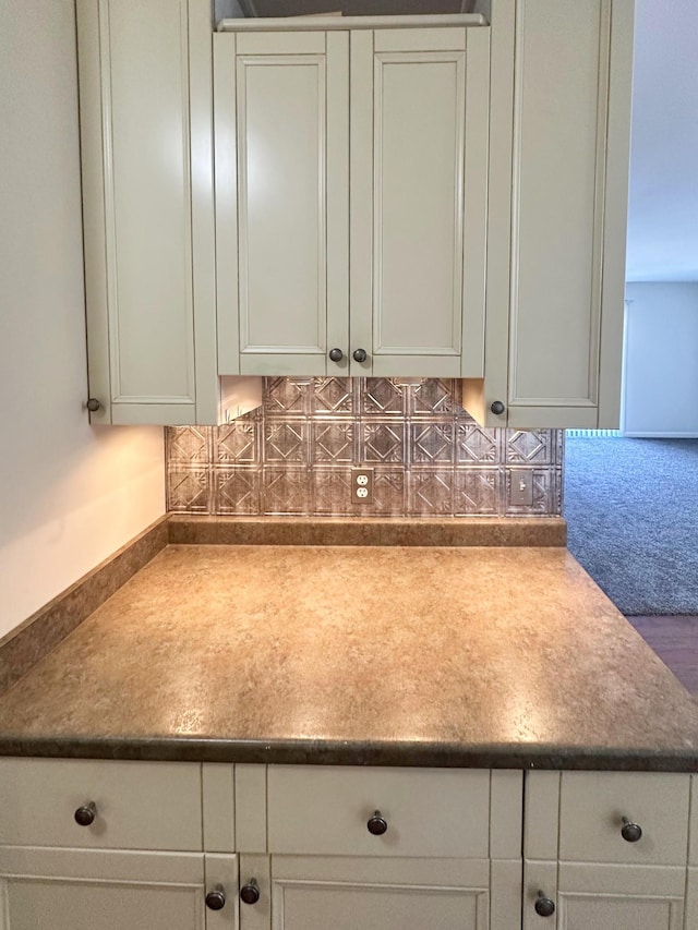 room details featuring white cabinets and backsplash