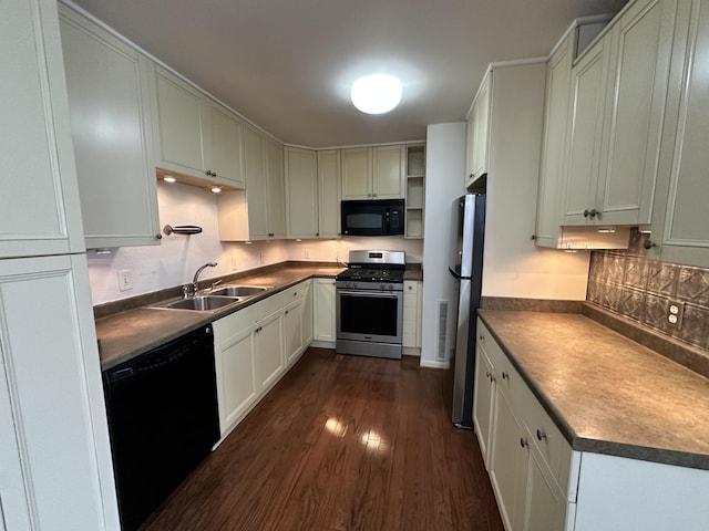 kitchen with black appliances, dark countertops, a sink, and dark wood finished floors