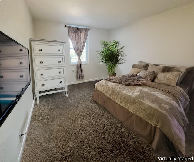 bedroom with dark colored carpet and baseboards