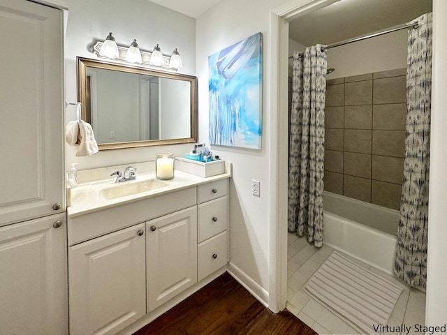 full bathroom with baseboards, wood finished floors, shower / tub combo with curtain, and vanity