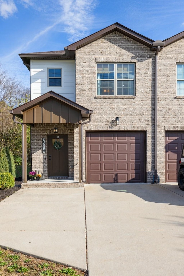 view of front of home featuring a garage, concrete driveway, and brick siding