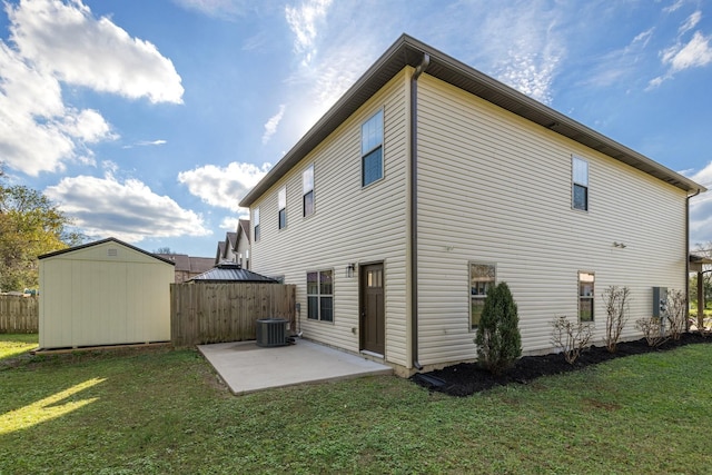 back of house featuring fence, an outdoor structure, central air condition unit, a patio area, and a shed