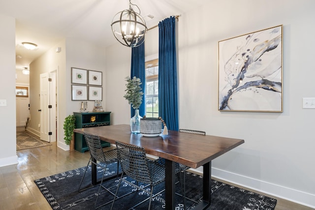 dining space with an inviting chandelier, baseboards, and wood finished floors