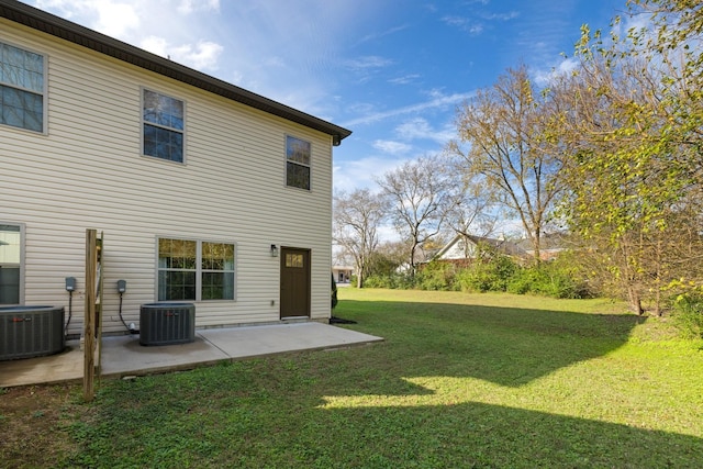 back of house featuring central air condition unit, a patio area, and a lawn