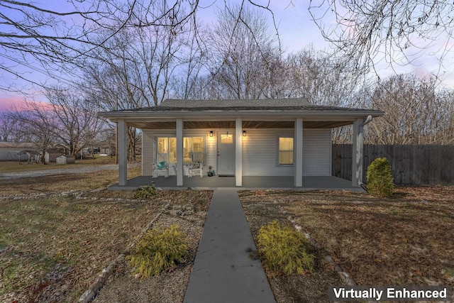 view of front facade with fence, a porch, and a patio