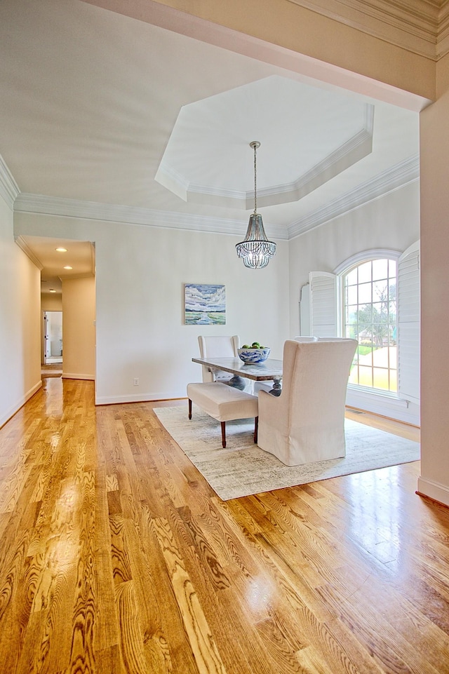 unfurnished dining area with light wood finished floors, baseboards, crown molding, and an inviting chandelier