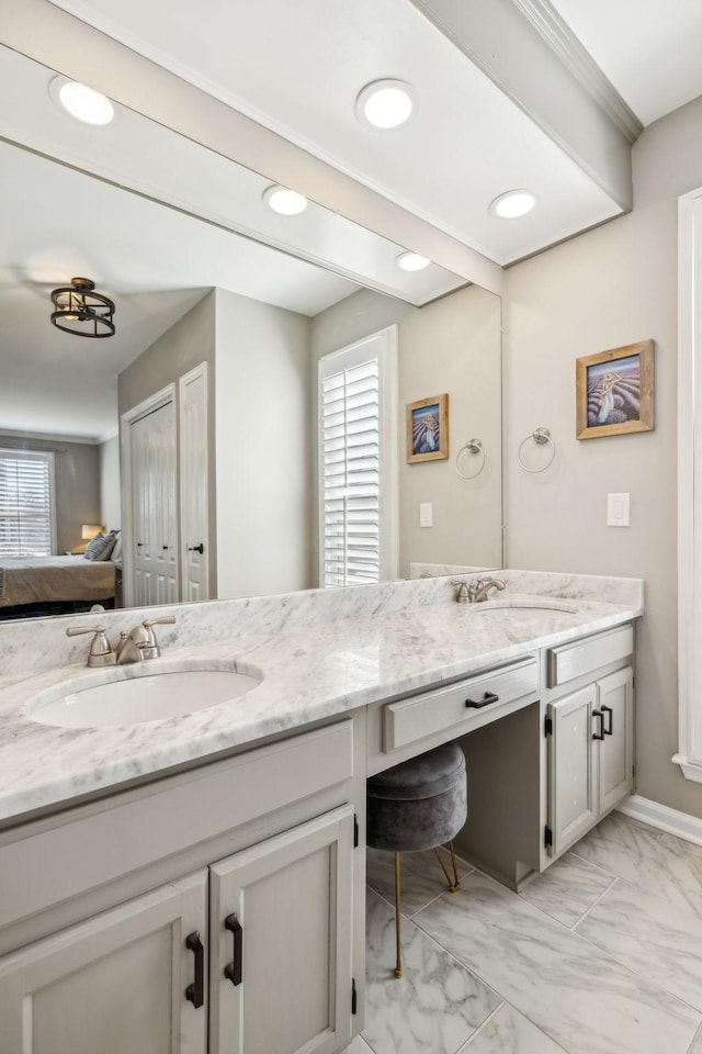 full bath with double vanity, marble finish floor, ensuite bath, and a sink