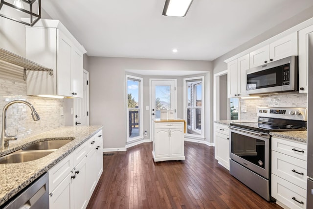 kitchen featuring white cabinetry, appliances with stainless steel finishes, light stone counters, and a sink