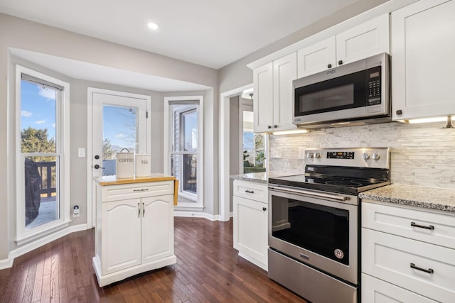 kitchen featuring appliances with stainless steel finishes, white cabinetry, and tasteful backsplash