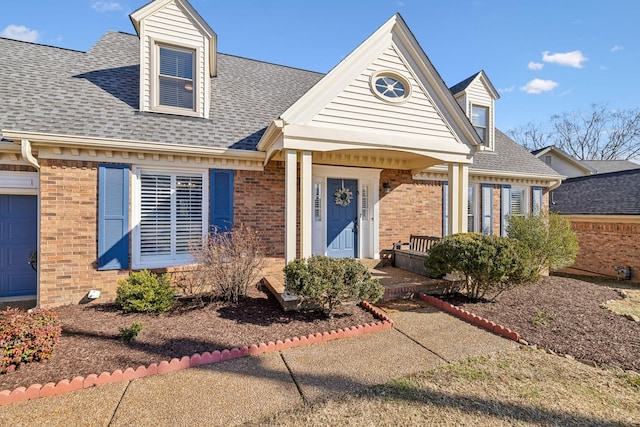 view of front of property featuring brick siding and a shingled roof