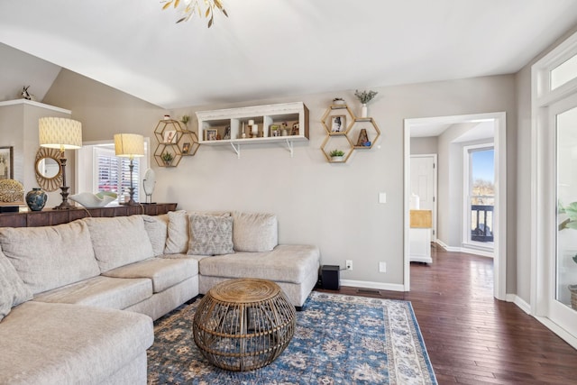 living area featuring lofted ceiling, dark wood-style flooring, a healthy amount of sunlight, and baseboards