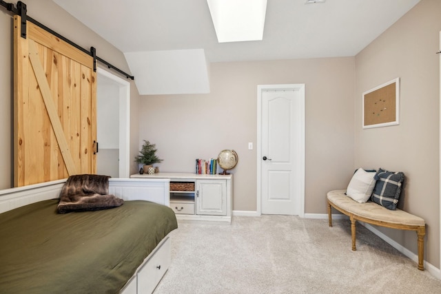 bedroom with light carpet, a skylight, a barn door, and baseboards