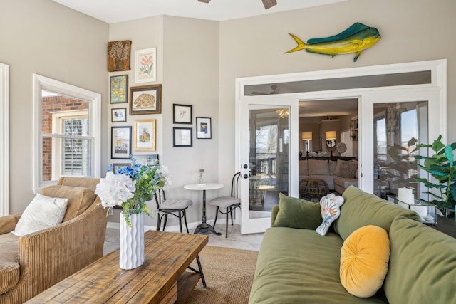 living room featuring marble finish floor, ceiling fan, and baseboards