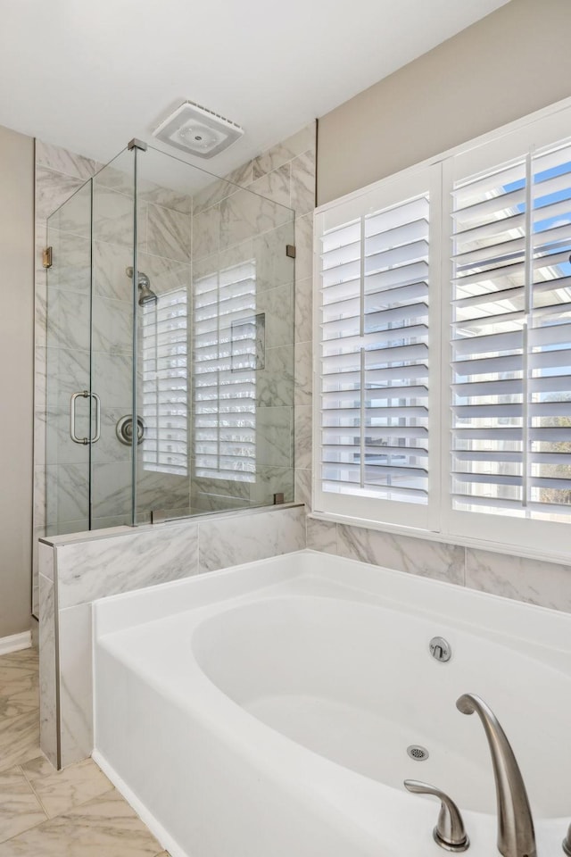 bathroom featuring marble finish floor, a shower stall, and a bath