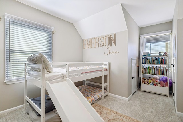 bedroom with baseboards, vaulted ceiling, and light colored carpet