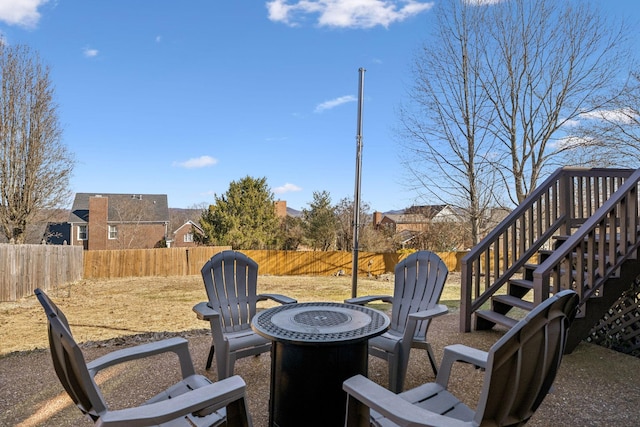 view of patio with an outdoor fire pit, stairway, and a fenced backyard