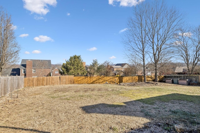 view of yard with a fenced backyard and a residential view