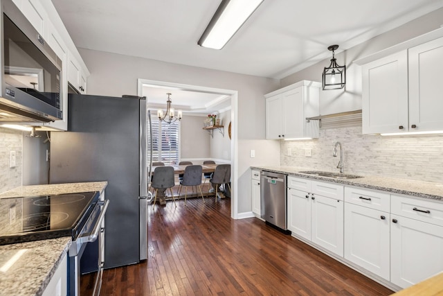 kitchen featuring dark wood-style flooring, a sink, white cabinets, appliances with stainless steel finishes, and pendant lighting