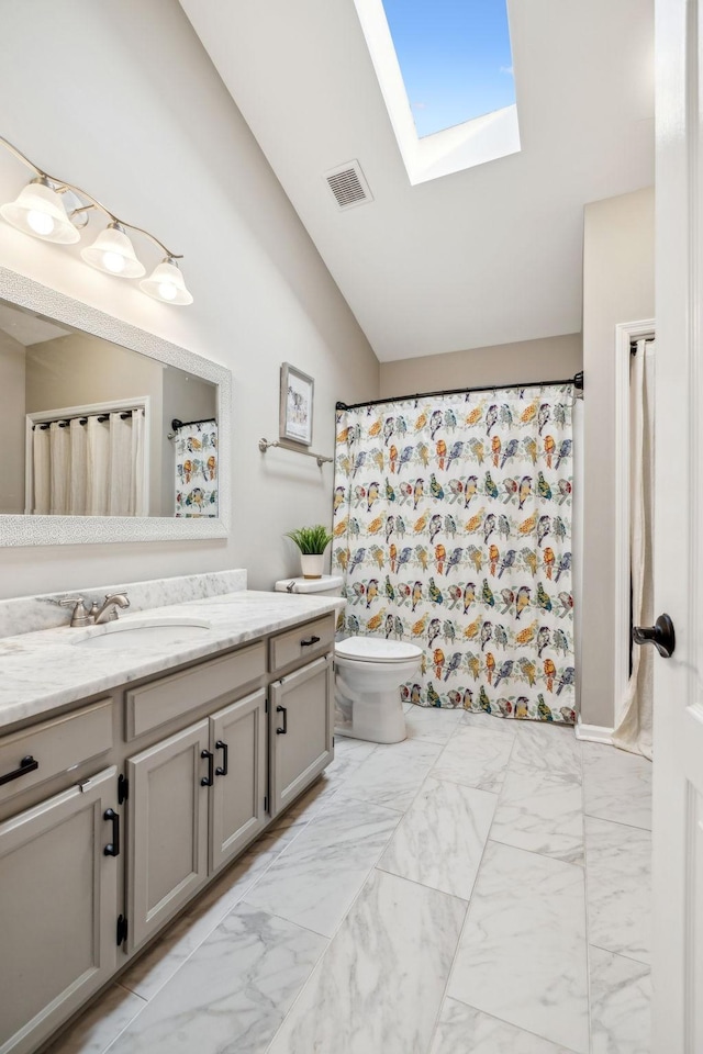 bathroom with vaulted ceiling with skylight, toilet, vanity, visible vents, and marble finish floor