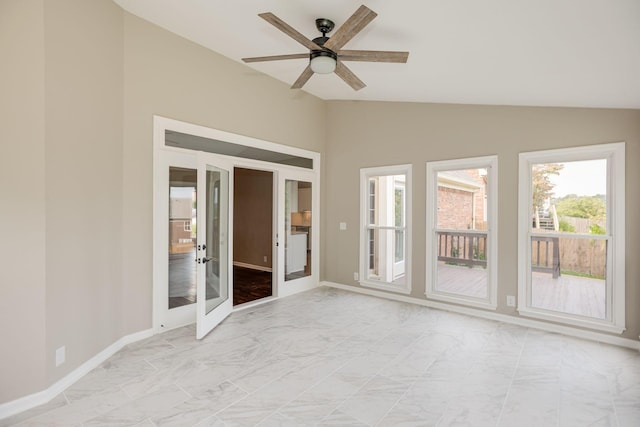 empty room with lofted ceiling, marble finish floor, ceiling fan, and baseboards