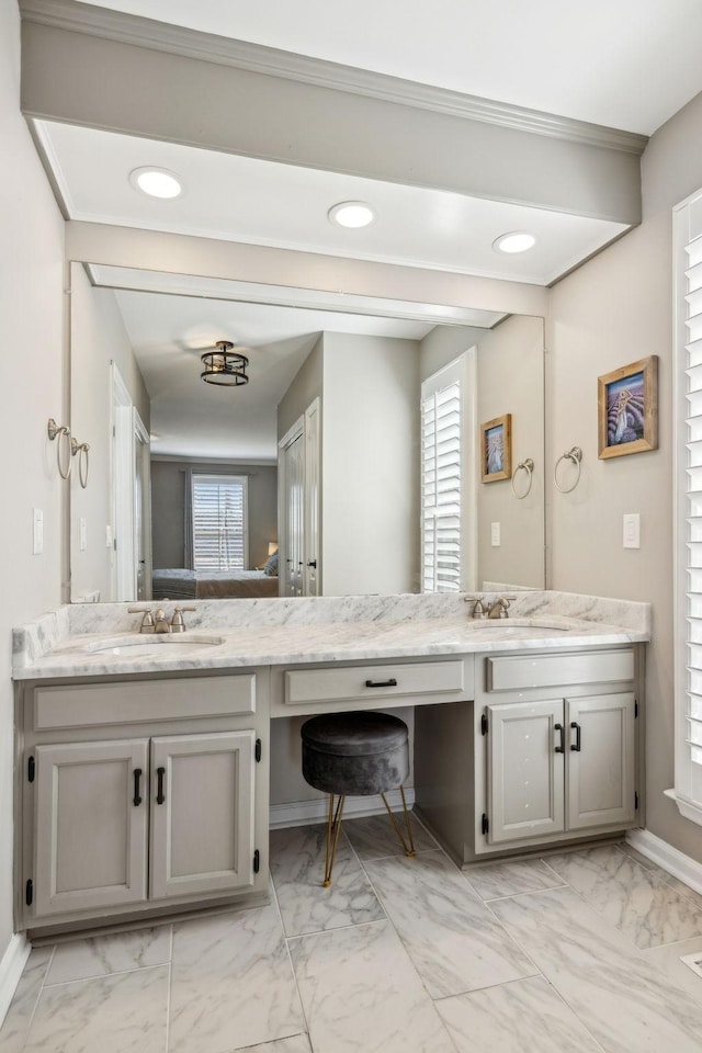 ensuite bathroom with marble finish floor, double vanity, recessed lighting, ensuite bathroom, and a sink