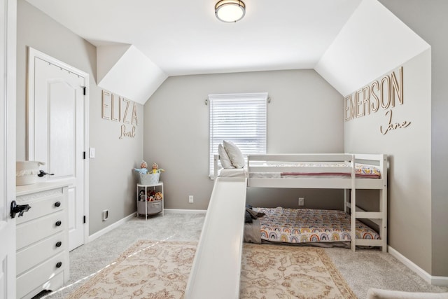 bedroom featuring vaulted ceiling, light carpet, and baseboards