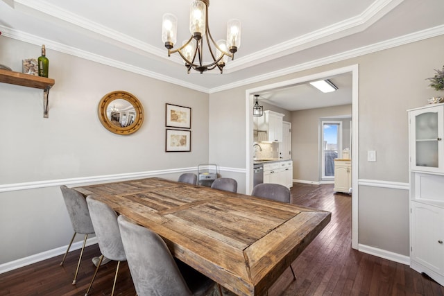 dining space with dark wood-style floors, ornamental molding, baseboards, and an inviting chandelier