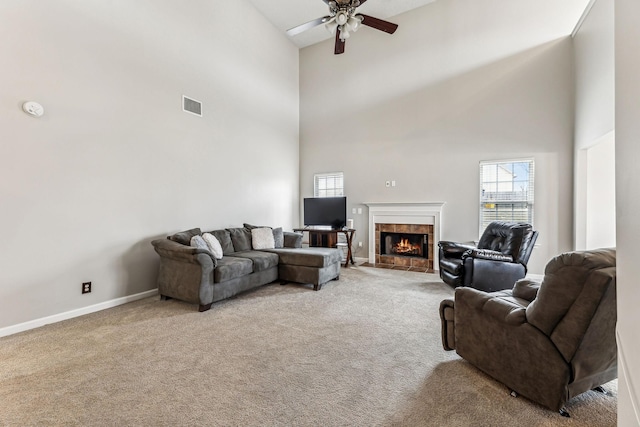 living room featuring light colored carpet, a fireplace, a ceiling fan, baseboards, and visible vents