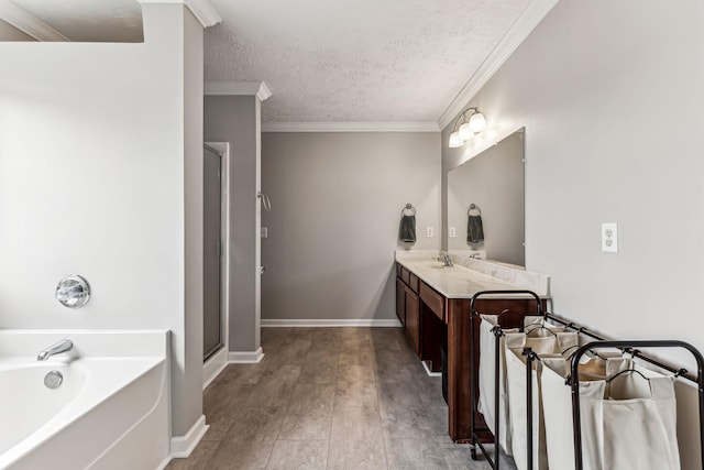 bathroom with wood finished floors, crown molding, vanity, a textured ceiling, and a bath