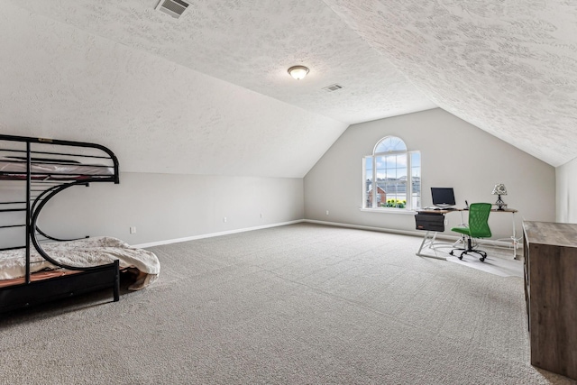 carpeted home office with baseboards, visible vents, vaulted ceiling, and a textured ceiling