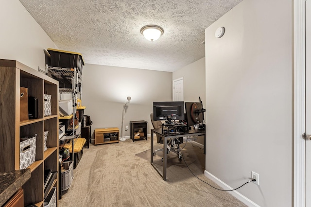 office space featuring light carpet, baseboards, and a textured ceiling