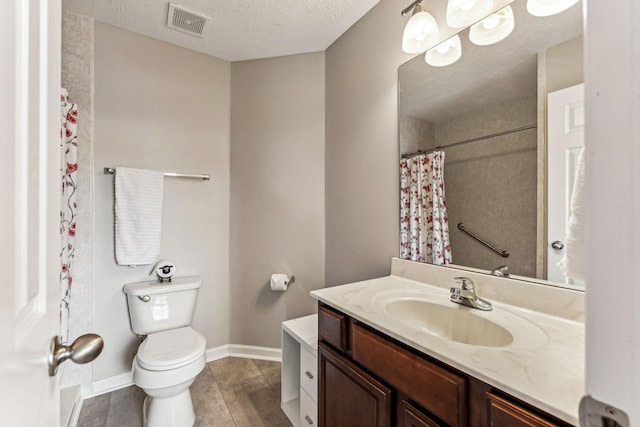 bathroom with visible vents, toilet, a textured ceiling, vanity, and baseboards