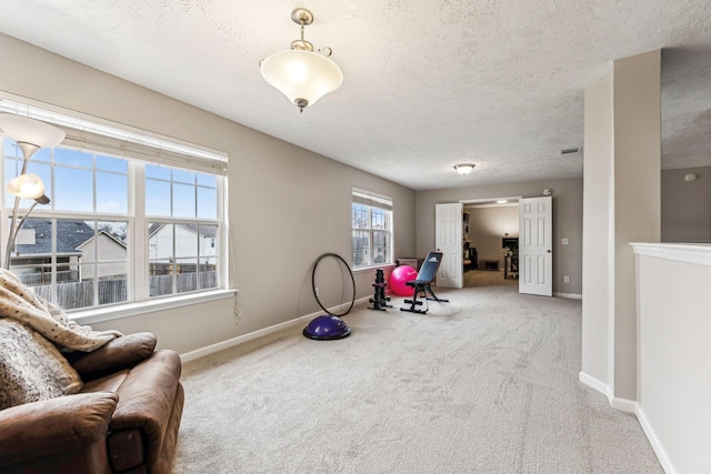 living area with carpet floors, a textured ceiling, and baseboards