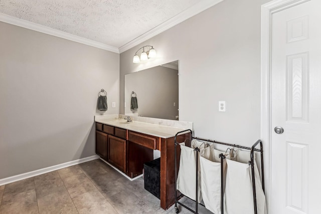 bathroom with a textured ceiling, baseboards, vanity, and crown molding