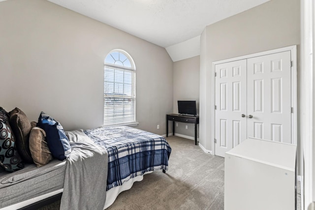 bedroom featuring a closet, baseboards, vaulted ceiling, and carpet flooring