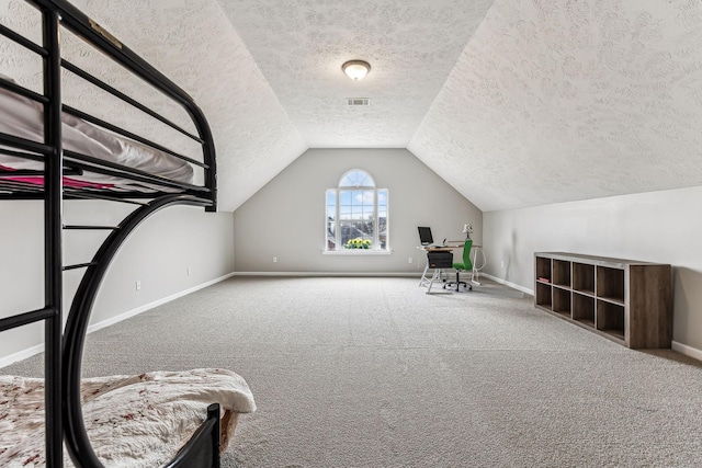 unfurnished bedroom with visible vents, baseboards, lofted ceiling, carpet, and a textured ceiling