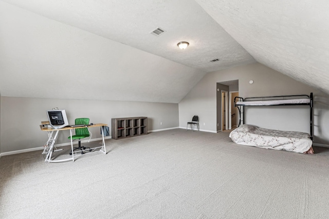 additional living space featuring a textured ceiling, lofted ceiling, visible vents, baseboards, and carpet