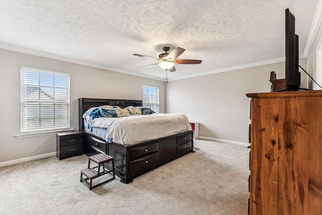 carpeted bedroom featuring ornamental molding, a textured ceiling, baseboards, and a ceiling fan