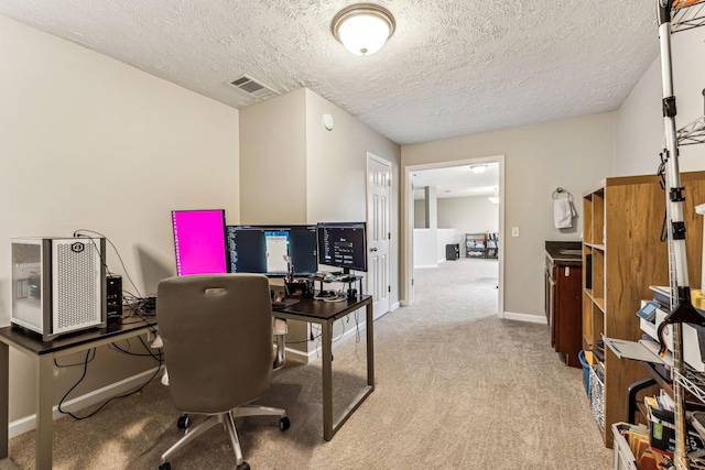 carpeted home office with a textured ceiling, visible vents, and baseboards