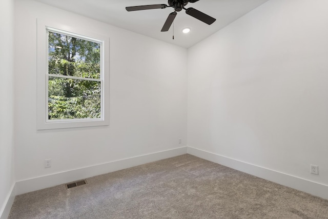 empty room featuring a ceiling fan, baseboards, visible vents, and carpet flooring