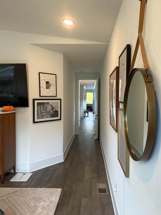 hallway with visible vents, dark wood finished floors, and baseboards