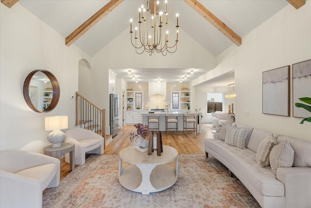 living area with light wood finished floors, high vaulted ceiling, and beam ceiling