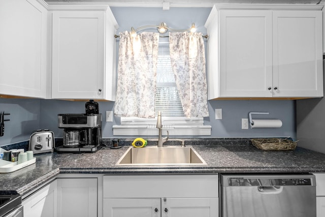 kitchen featuring stainless steel appliances, dark countertops, a sink, and white cabinets