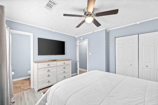 bedroom featuring ceiling fan, visible vents, a closet, light wood-type flooring, and crown molding