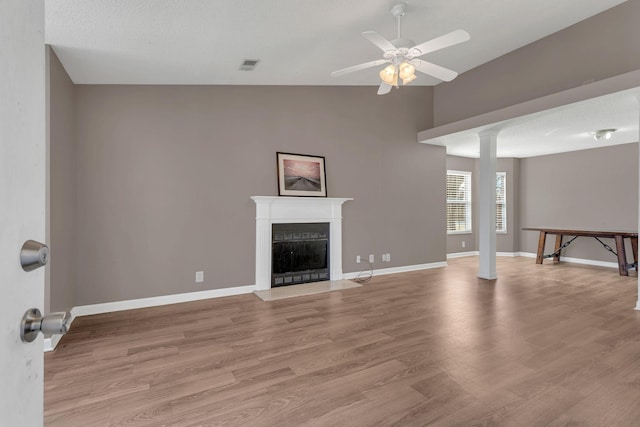 unfurnished living room with light wood-style floors, baseboards, a fireplace, and visible vents