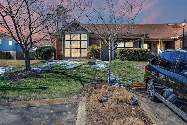 single story home featuring a chimney, a front yard, and fence