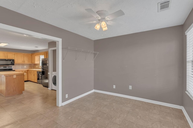 interior space featuring light floors, washer / dryer, visible vents, and baseboards