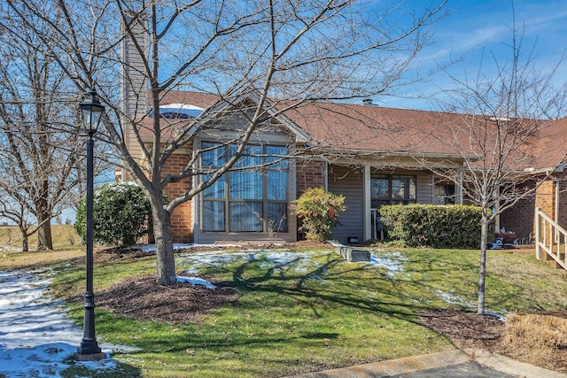 view of front facade featuring a front yard and a shingled roof